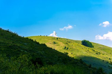Güneşli bir günde mavi gökyüzüne karşı güneş tarafından aydınlatılan tepeler. Rusya, Altai toprağı