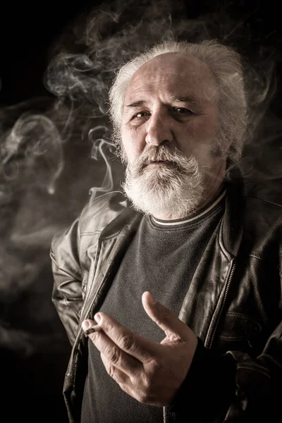 Pria Senior Pemarah Merokok Rokok Terhadap Latar Belakang Gelap — Stok Foto