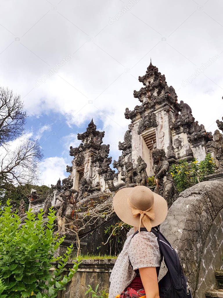 Female tourist with hat and sarong at Lempuyang temple