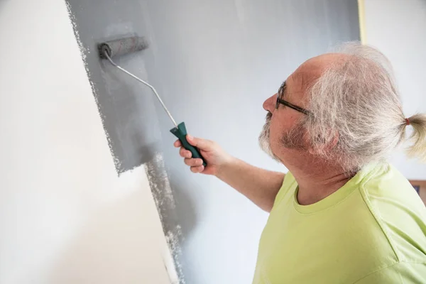 Divertente anziano uomo pittura il muro — Foto Stock