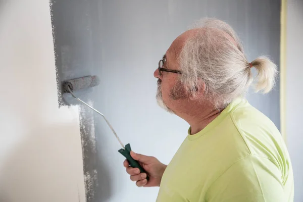 Divertente anziano uomo pittura il muro — Foto Stock