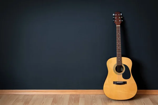 Guitarra acústica em sala vazia Fotos De Bancos De Imagens