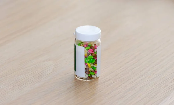 Pílulas multicoloridas em um frasco para injetáveis — Fotografia de Stock