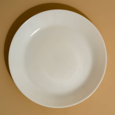 Bej renkli arka plan üzerinde beyaz tabak