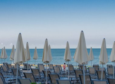 Plaj şemsiyeleri ve güneş yatakları