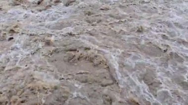 Kirli köpüren çamurlu su akıntısı. Kahverengi renkli fırtınalı dağ nehri. Şiddetli yağışlardan sonra sel. Felaket