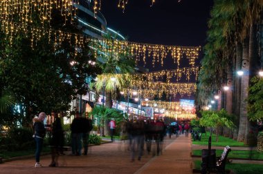 Yürüyen bir sokakta hareket halindeki insanların bulanık figürleri