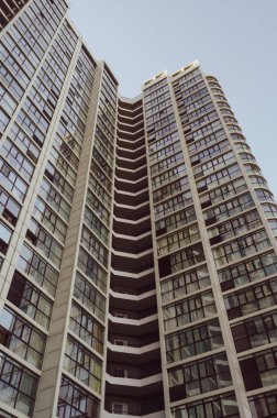 Kavisli yüksek katlı bir binanın cephesinin bir kısmı