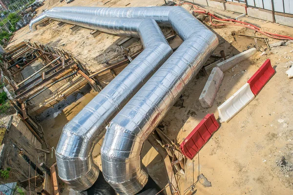 İnşaat alanında parlak metal borular ve boru hattı döşeme tesisatı