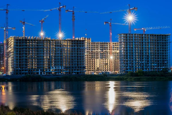 İnşaat halindeki çok katlı binalar güçlendirilmiş beton yapılar ve iskeletlerden oluşuyor. Geceleri göletin yanında vinçler ve yansıyan ışıklar ve suda parlayan parlaklıklar var..