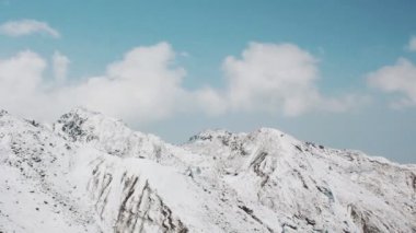 Karlı dağların üzerinden uçan helikopter