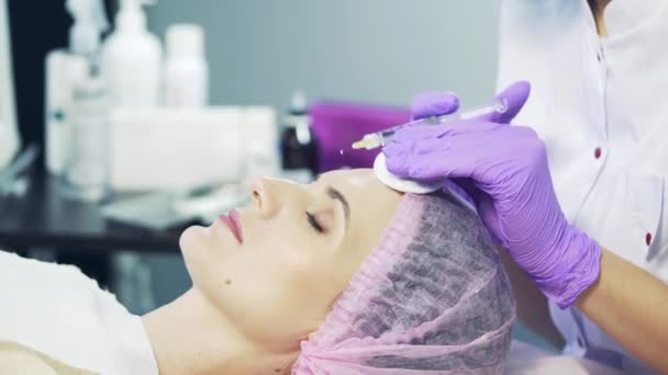 Cosmetologist makes the rejuvenating facial injections procedure on the face skin in a beauty salon — Stock Video