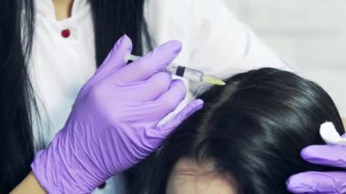 Doktor hasta baş kozmetik ofiste iğneleyici bir enjeksiyon şırınga ile. Genç kadın saç kaybı sorunu alıcı enjeksiyon ile. Yakın çekim