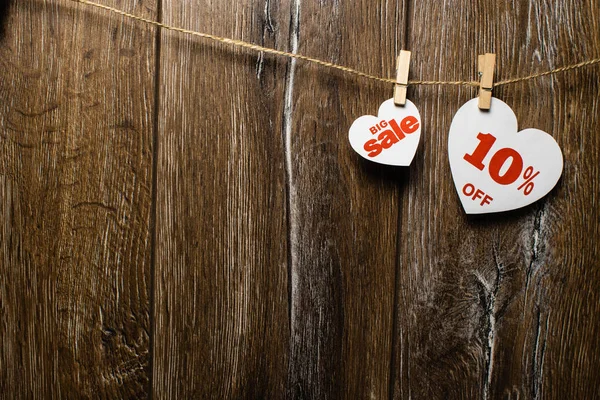 İki kupa ve indirimler ile romantik desen ahşap arka plan üzerinde beyaz. Büyük bir kalp satışında ve başka bir ipe clothespins tarafından asılı üzerinde yüzde on