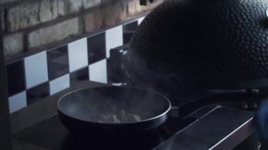 Mantar alkol ile yemek ve bir tavada bir mutfak soba üzerinde alev. Şef mantar ateşle hazırlanıyor