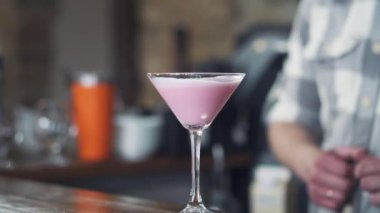 Lezzetli pembe kokteyl Çubuğu'nda bir cam yerleştirerek barmen istemci için sayaç. Parti için lezzetli kokteyl bardak