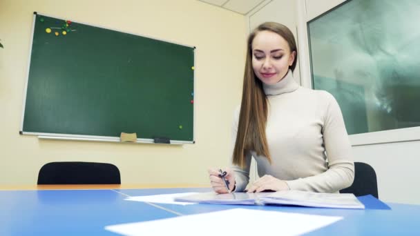 Studenten Gör Läxor Klassrummet Vid Bordet Bakgrunden Svarta Tavlan — Stockvideo