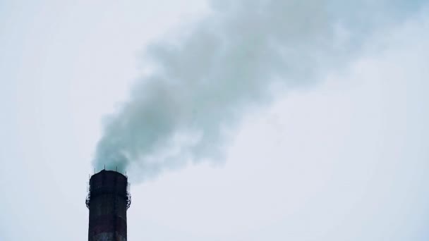Humo de una chimenea de fábrica contra un cielo gris nublado — Vídeos de Stock