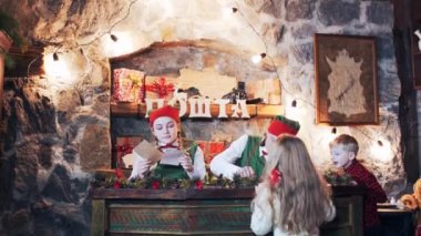 Çocuklar ve elfler Noel Baba 'nın evine bir mektup yolluyor.