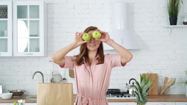 Mutfaktaki Gülümseyen Kız Ellerinde Yeşil Elmaları Tutuyor Onlarla Gözlerini Kapatıyor — Stok video