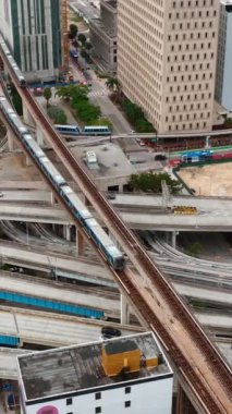 Miami şehir merkezindeki modern ulaşım merkezi. Arabalarla kavşaklar. Trenli metro hattı. Hafta içi banliyö treniyle. Dikey.