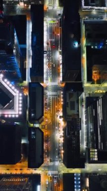 Geceleri Philadelphia sokaklarında araba trafiği, ışıklar, trafik ışıkları. Hava görüntüsü. Şehir merkezindeki yol ve gökdelenlerin üzerinden uç. Dikey.