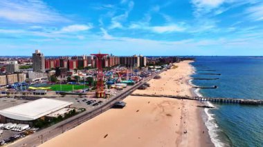 Coney Adası Sahili 'nin havadan görünüşü ve yukarıdan eğlence parkı. İskeleli kumsal. Mavi gökyüzü ile güneşli yaz günü.