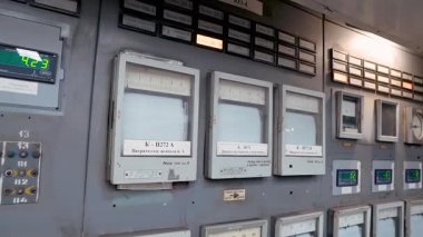 Göstergeleri, voltmetreleri, düğmeleri ve ekranları olan eski bir Sovyet kömür santralinin kontrol paneli.
