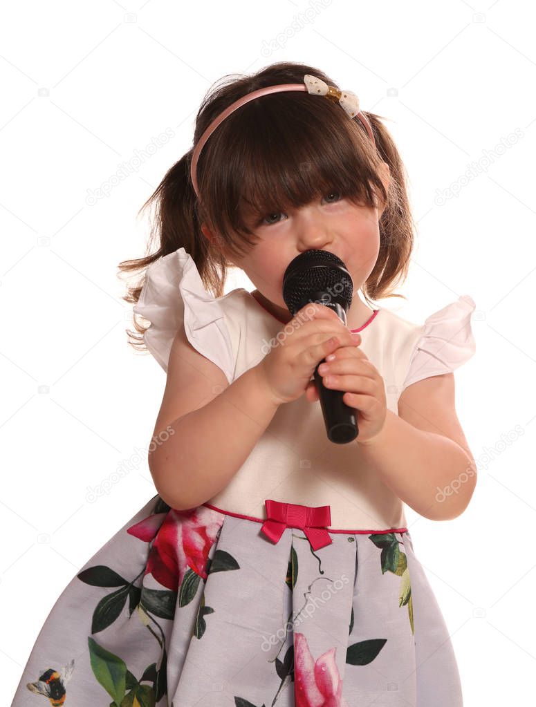 toddler girl singing in a microphone