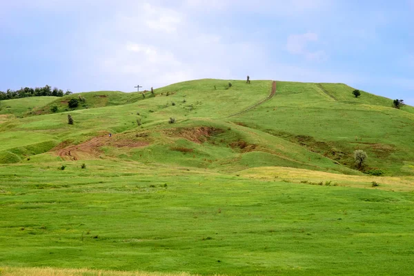 Zielone wzgórze z krzyżem na szczycie — Zdjęcie stockowe