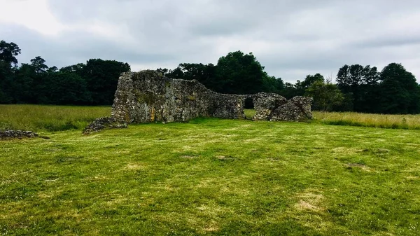 Old ruins in England. Green fields near old castle. Landscape view.