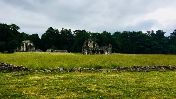 Old ruins in England. Green fields near old castle. Landscape view.