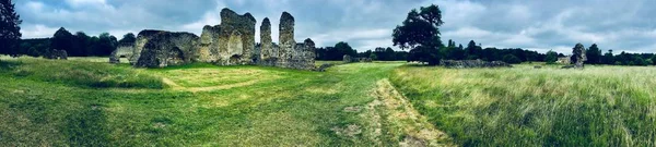 Old ruins in England. Green fields near old castle. Landscape view.