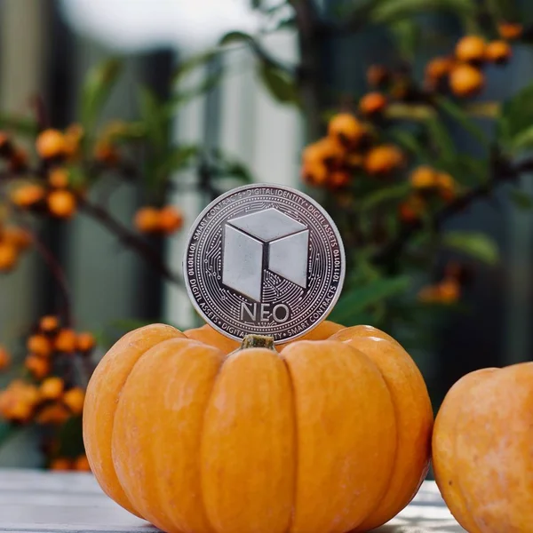 Digital currency physical silver metal neo coin. Orange halloween concept.