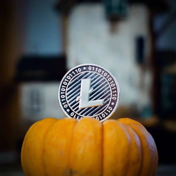 Digital currency physical metal litecoin coin. Cryptocurrency halloween concept.