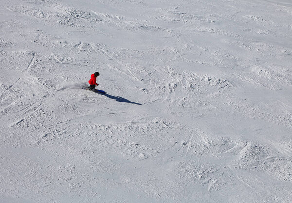 One skier in the slope with snow with red clothing