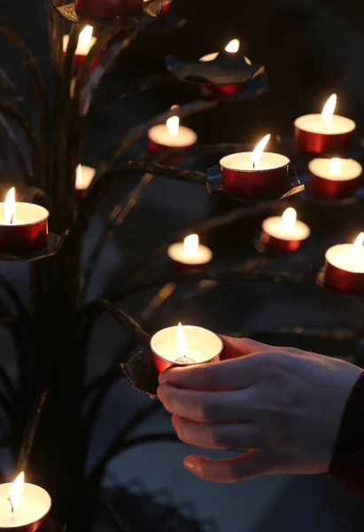 孩子的手和许多蜡烛在教会期间在圣洁弥撒期间 — 图库照片