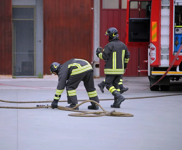 Два Пожежники Які Стріляють Дії Розгортають Водопровідні Труби — стокове фото