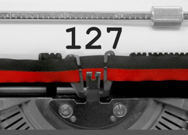 Eski bir daktilo tarafından beyaz kağıda yazılı 127 numarası metni