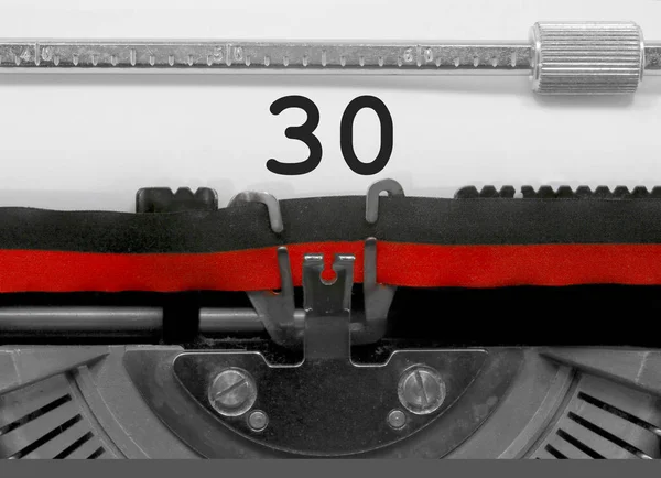 Eski bir daktilo tarafından beyaz kağıda yazılı 30 sayı metin