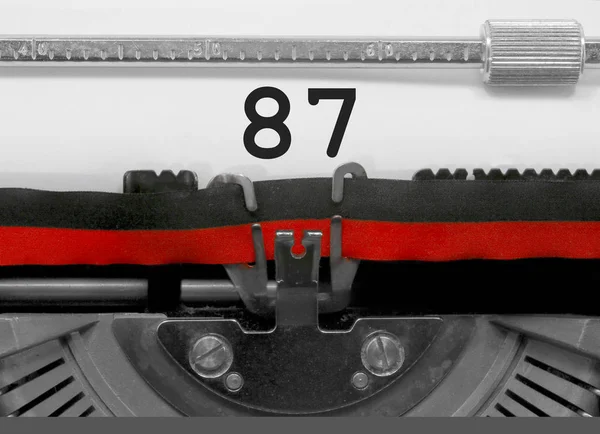 Eski bir daktilo tarafından beyaz kağıda yazılı 87 numarası metni