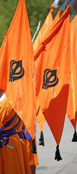 big orange flag with symbol of Sikh called Khanda during a religious ceremony