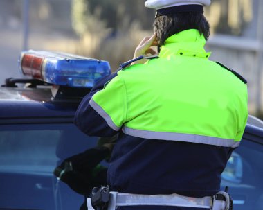 Polis arabaları ve fosforlu bir üniformalı polis acil arama sırasında cep telefonlarını kullanmak