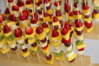 bir sürü meyve ananas çilek kivi muz ile pek çok şiş