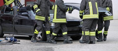 İtfaiyeciler bir trafik kazasından sonra bir araba enkazı giderilmesinde nişanlı
