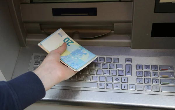 boy takes money at atm machine in europe