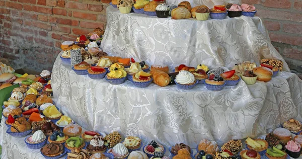 婚礼招待会与一个多层表充满美味的糕点制成的新鲜水果奶油 — 图库照片