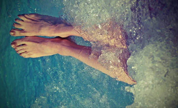 ツーリスト ビレッジのプールの温水浴槽でリラックスする女性の足 — ストック写真