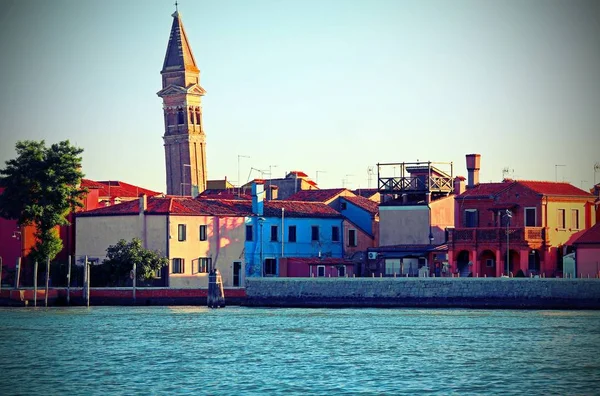 Sea and the island of Burano with colorful houses and the leaning bell tower near Venice in Italy