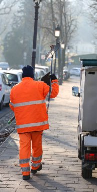 turuncu giymiş süpürmek sokak kuru yapraklarından temizleyicileri
